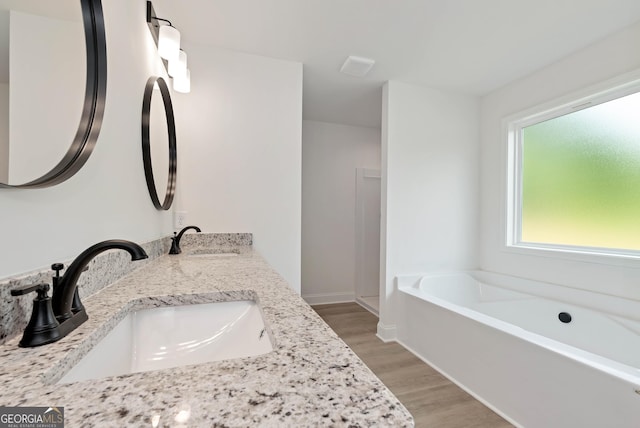 797 Ode Peppers Rd, Winder, GA 30680 - full bathroom with wood finished floors, double vanity, and a garden tub