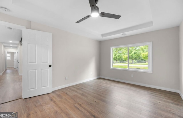 6402 Kensington Ct, Austell, GA 30106 - unfurnished room with wood finished floors, ceiling fan, a smoke detector, and a raised ceiling
