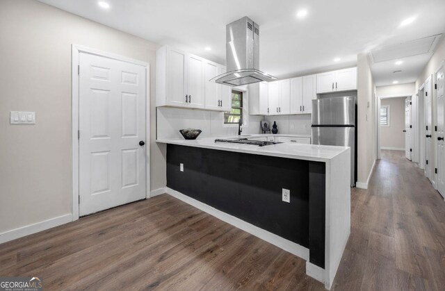 6402 Kensington Ct, Austell, GA 30106 - kitchen featuring island range hood, freestanding refrigerator, a peninsula, white cabinets, and dark wood-style floors