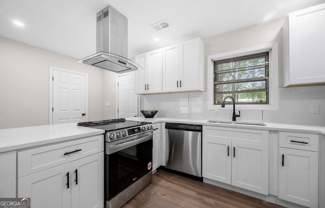 6402 Kensington Ct, Austell, GA 30106 - kitchen featuring stainless steel appliances, island range hood, white cabinetry, dark wood-style floors, and light countertops