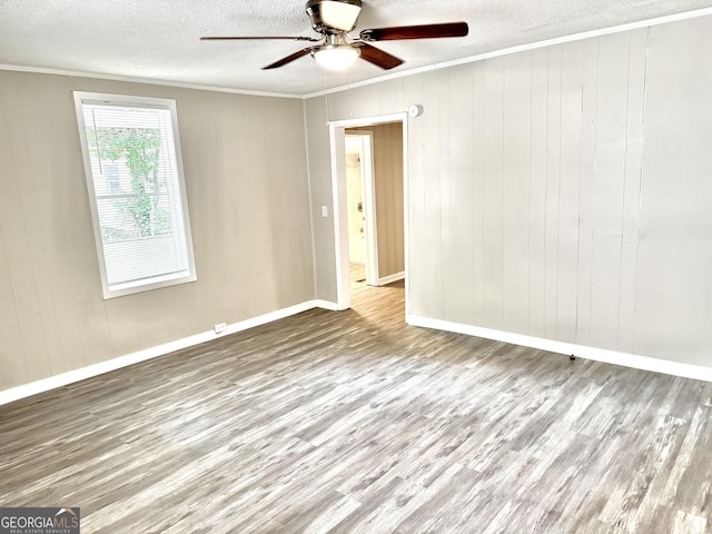 708 Degroat St, Lagrange, GA 30241 - empty room featuring crown molding, wood finished floors, a textured ceiling, a ceiling fan, and wood walls