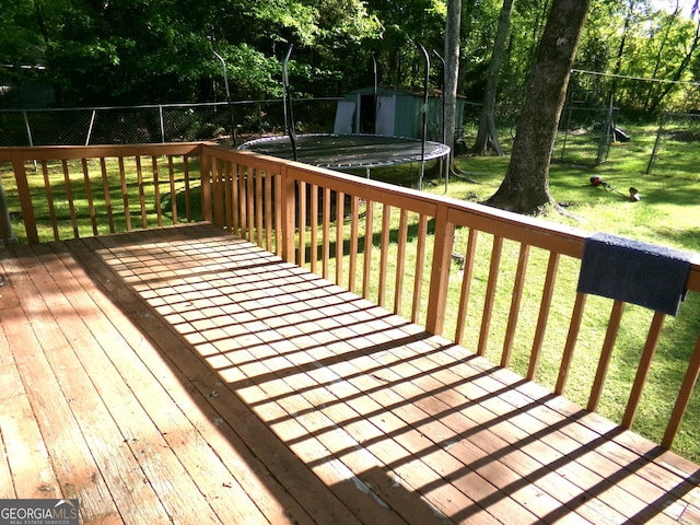 871 Chisholm Trl, Macon, GA 31220 - wooden terrace featuring a trampoline, a storage shed, and view of wooded area