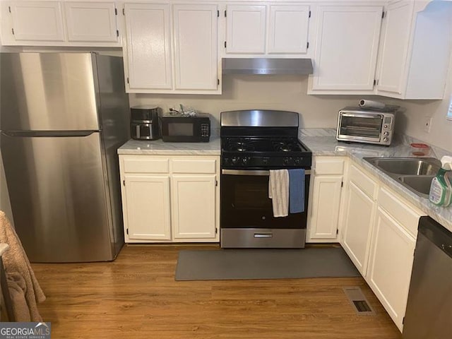 8955 Stonebridge Blvd, Douglasville, GA 30134 - kitchen with stainless steel appliances, under cabinet range hood, light countertops, and white cabinetry
