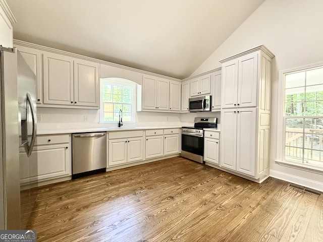 83 Austin Ct, Dahlonega, GA 30533 - kitchen with appliances with stainless steel finishes, lofted ceiling, wood finished floors, light countertops, and white cabinets