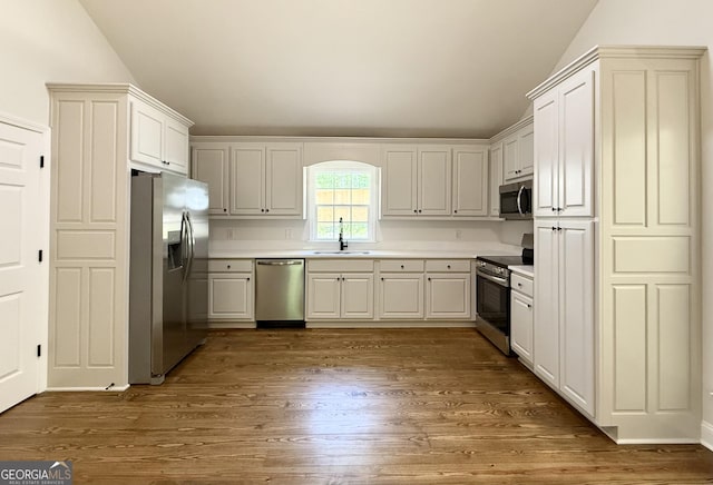 83 Austin Ct, Dahlonega, GA 30533 - kitchen featuring stainless steel appliances, lofted ceiling, dark wood-type flooring, and light countertops