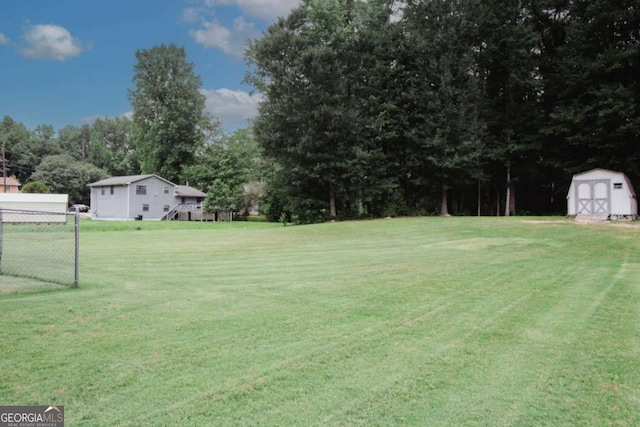 125 Pebble Beach Ct, Atlanta, GA 30349 - view of grassy yard featuring a storage shed and view of scattered trees