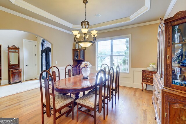 805 Cog Hl, Mcdonough, GA 30253 - dining room featuring arched walkways, a raised ceiling, a chandelier, light wood-style flooring, and a wainscoted wall