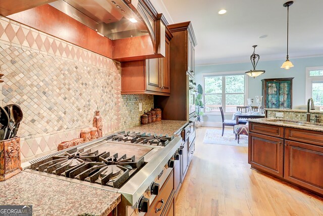 805 Cog Hl, Mcdonough, GA 30253 - kitchen with custom exhaust hood, light wood-style flooring, ornamental molding, healthy amount of natural light, and tasteful backsplash