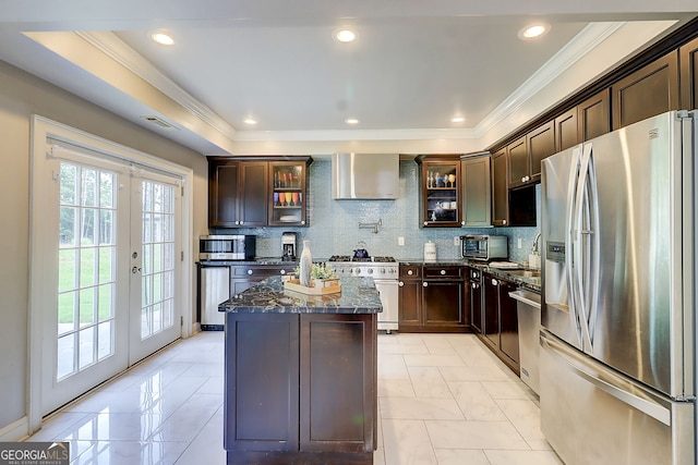 805 Cog Hl, Mcdonough, GA 30253 - kitchen featuring appliances with stainless steel finishes, wall chimney range hood, french doors, dark stone countertops, and a kitchen island