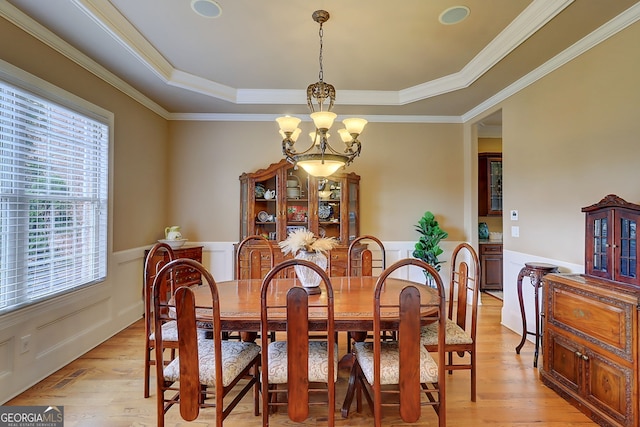 805 Cog Hl, Mcdonough, GA 30253 - dining area with a chandelier, a tray ceiling, light wood-type flooring, a wainscoted wall, and crown molding