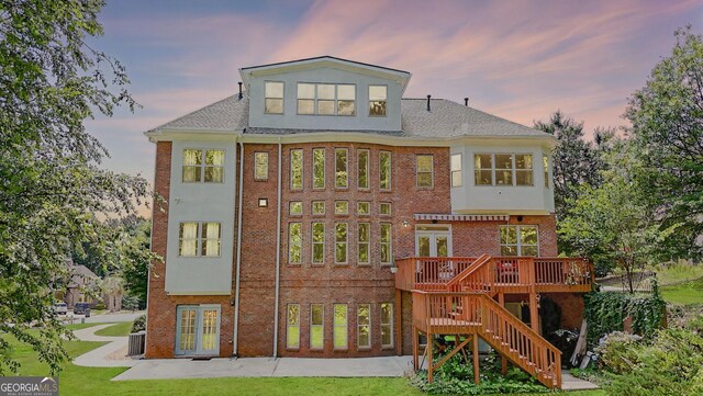 805 Cog Hl, Mcdonough, GA 30253 - back of house at dusk with stairs, brick siding, a wooden deck, and french doors