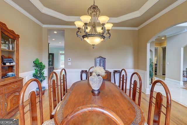 805 Cog Hl, Mcdonough, GA 30253 - dining area featuring wood finished floors, crown molding, a chandelier, arched walkways, and wainscoting