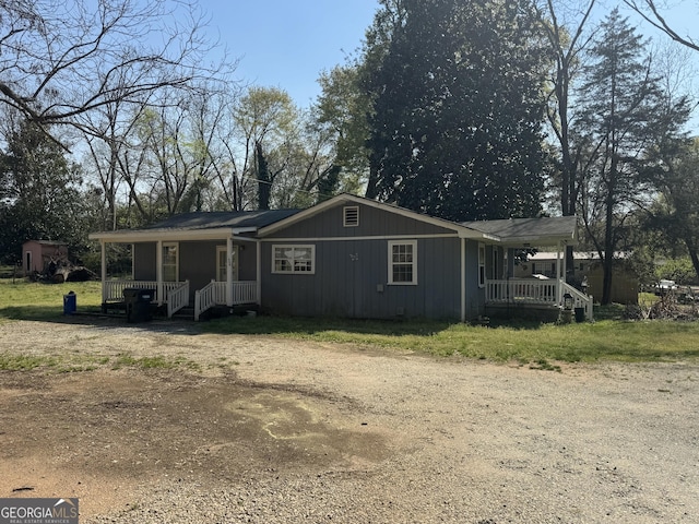 1004 Mapp St, Madison, GA 30650 - view of front of house featuring a porch, a storage unit, and dirt driveway