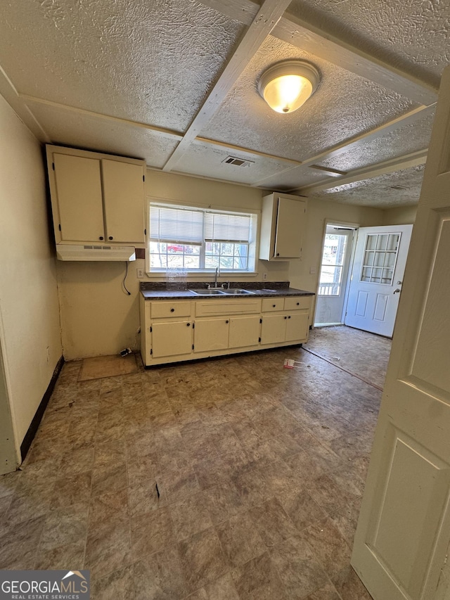 1004 Mapp St, Madison, GA 30650 - kitchen with cream cabinetry, dark countertops, a textured ceiling, and tile patterned floors