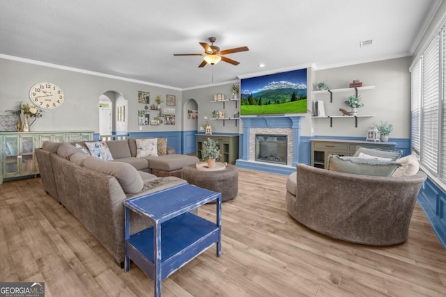89 Crestview Dr, Guyton, GA 31312 - living room with arched walkways, ceiling fan, wood finished floors, crown molding, and a glass covered fireplace