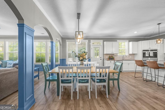 89 Crestview Dr, Guyton, GA 31312 - dining room with crown molding, light wood-type flooring, arched walkways, and recessed lighting