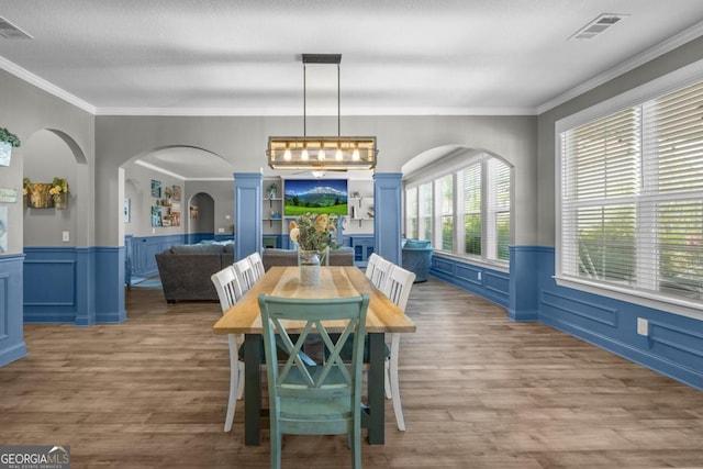 89 Crestview Dr, Guyton, GA 31312 - dining area with wood finished floors, ornamental molding, arched walkways, and wainscoting