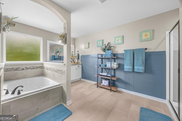 89 Crestview Dr, Guyton, GA 31312 - bathroom with a garden tub, vanity, a shower stall, and a wainscoted wall