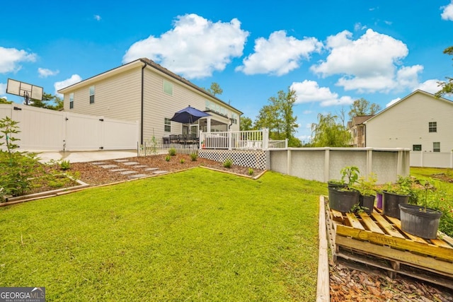 89 Crestview Dr, Guyton, GA 31312 - fenced backyard featuring a gate, a wooden deck, and a swimming pool