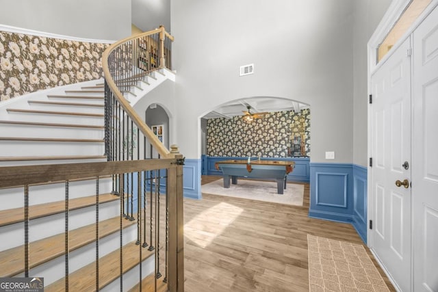 89 Crestview Dr, Guyton, GA 31312 - foyer featuring a wainscoted wall, stairway, wood finished floors, arched walkways, and a towering ceiling