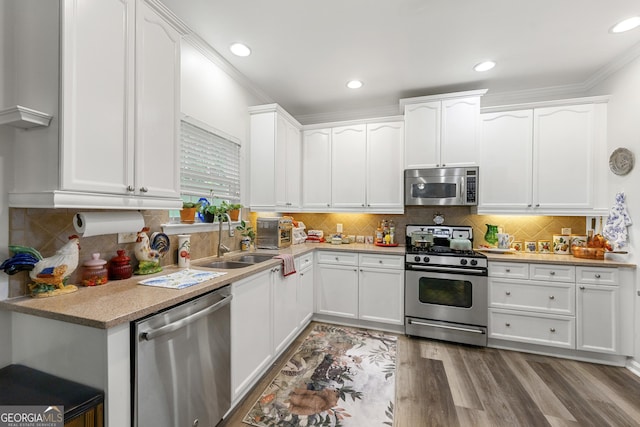 58 Lilyfield Ln, Acworth, GA 30101 - kitchen with appliances with stainless steel finishes, white cabinetry, crown molding, wood finished floors, and decorative backsplash