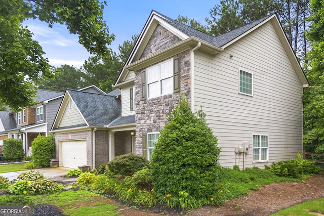 58 Lilyfield Ln, Acworth, GA 30101 - view of side of property with stone siding, a garage, roof with shingles, and driveway