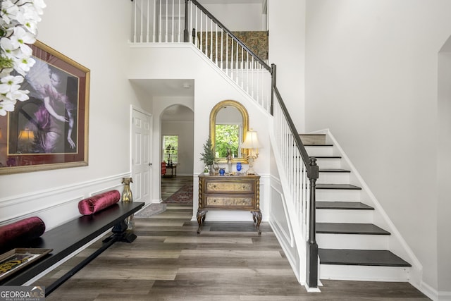 58 Lilyfield Ln, Acworth, GA 30101 - staircase featuring arched walkways, a towering ceiling, and wood finished floors