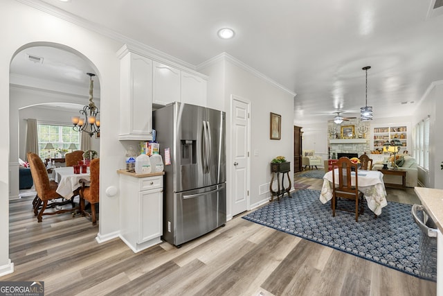 58 Lilyfield Ln, Acworth, GA 30101 - kitchen with stainless steel appliances, light wood-style floors, white cabinets, arched walkways, and crown molding