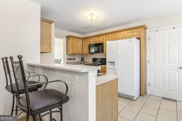 8810 Brookhurst Trl, Gainesville, GA 30506 - kitchen with black appliances, a breakfast bar area, light countertops, light tile patterned floors, and a peninsula