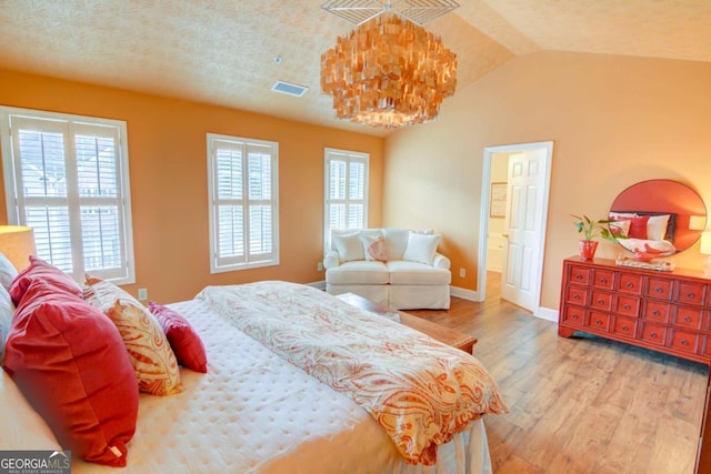 2557 Avery Park Cir, Atlanta, GA 30360 - bedroom featuring wood finished floors, lofted ceiling, a chandelier, and ensuite bath