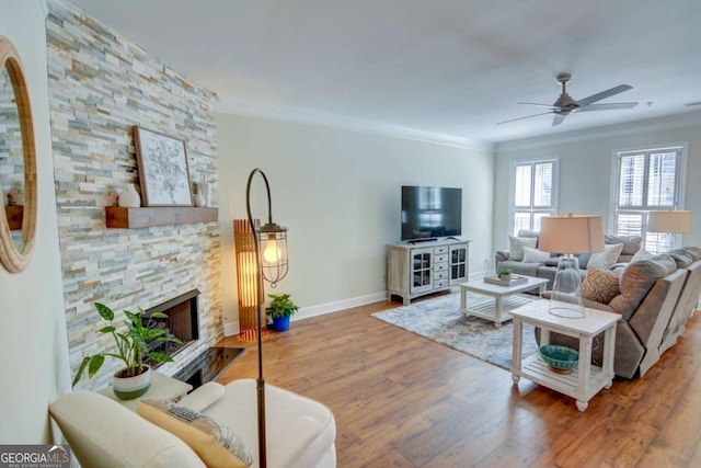 2557 Avery Park Cir, Atlanta, GA 30360 - living room with crown molding, a ceiling fan, wood finished floors, a stone fireplace, and arched walkways