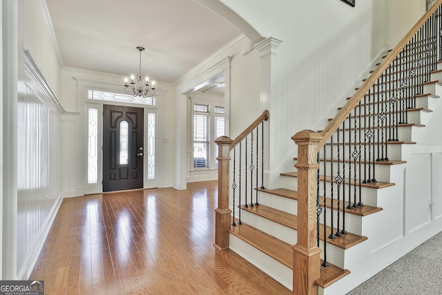 118 Fire Creek Trl, Senoia, GA 30276 - foyer featuring ornamental molding, arched walkways, a chandelier, stairs, and wood finished floors