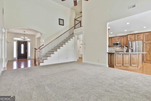 118 Fire Creek Trl, Senoia, GA 30276 - entrance foyer with light carpet, a chandelier, a towering ceiling, arched walkways, and ceiling fan