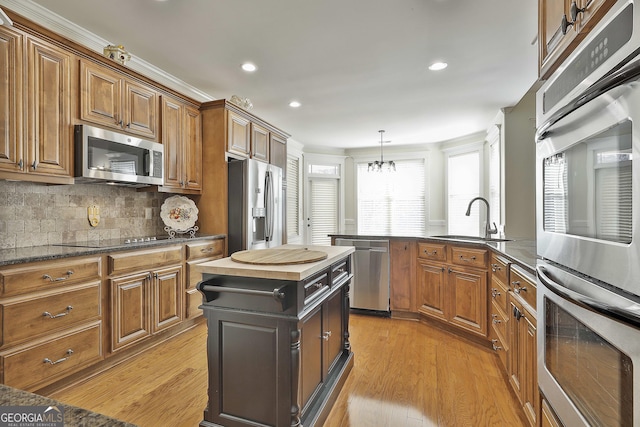 118 Fire Creek Trl, Senoia, GA 30276 - kitchen featuring stainless steel appliances, brown cabinetry, light wood-style floors, tasteful backsplash, and recessed lighting