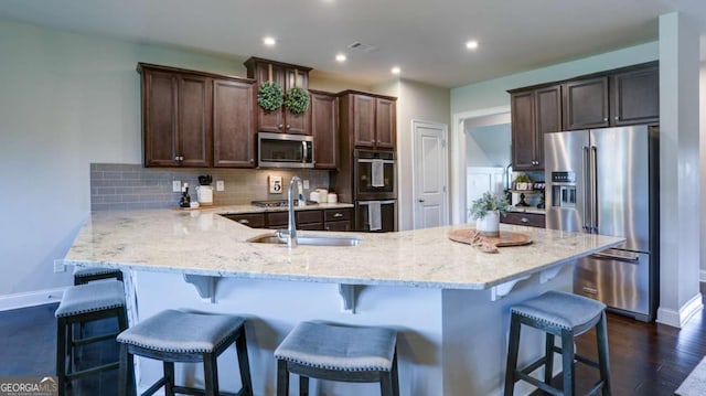 8325 Post Oak Ln, Gainesville, GA 30506 - kitchen with stainless steel appliances, a peninsula, dark brown cabinets, backsplash, and light stone countertops
