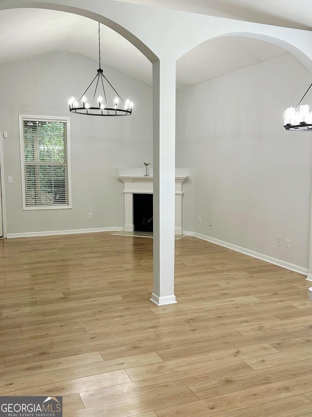 6834 White Walnut Way, Braselton, GA 30517 - unfurnished living room featuring a chandelier, light wood-style floors, lofted ceiling, and a fireplace