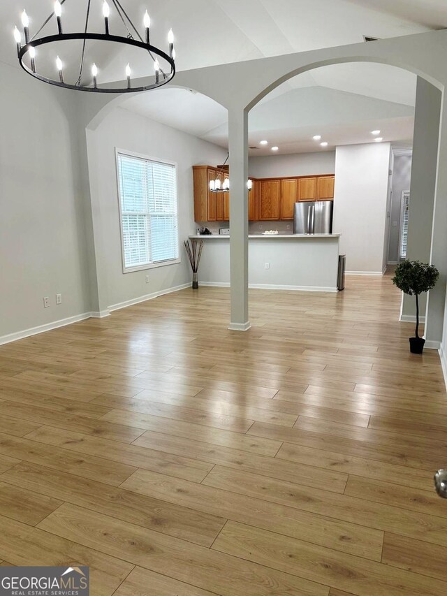 6834 White Walnut Way, Braselton, GA 30517 - unfurnished living room with a chandelier, arched walkways, recessed lighting, and light wood-style floors