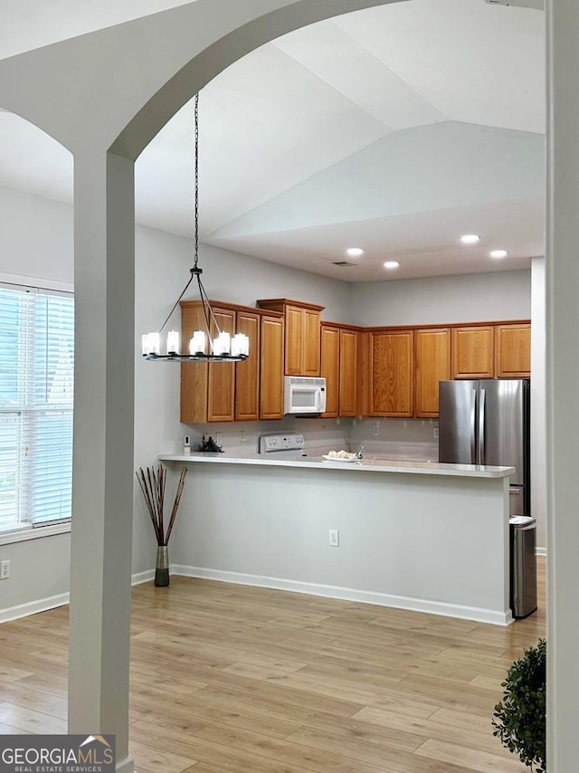 6834 White Walnut Way, Braselton, GA 30517 - kitchen featuring white microwave, freestanding refrigerator, light wood-type flooring, light countertops, and arched walkways