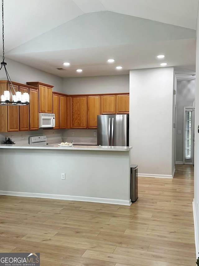 6834 White Walnut Way, Braselton, GA 30517 - kitchen with white appliances, lofted ceiling, light countertops, brown cabinetry, and decorative light fixtures