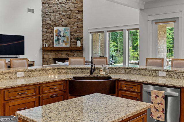 150 Dean Dr, Tyrone, GA 30290 - kitchen with dishwasher, open floor plan, light stone countertops, brown cabinetry, and ornamental molding