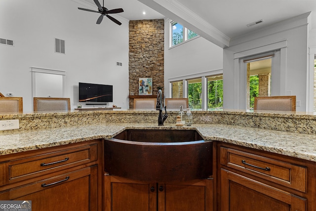 150 Dean Dr, Tyrone, GA 30290 - kitchen with a towering ceiling, ceiling fan, light stone countertops, open floor plan, and brown cabinets