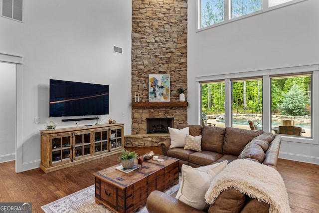 150 Dean Dr, Tyrone, GA 30290 - living room featuring a towering ceiling, wood finished floors, and a stone fireplace