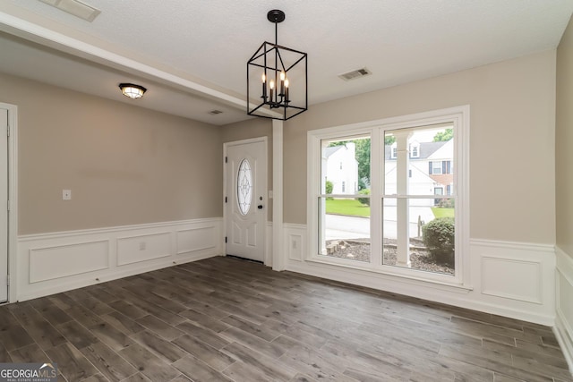 2801 Priestcliff Dr, Smyrna, GA 30080 - entryway featuring dark wood finished floors, a chandelier, wainscoting, and a decorative wall