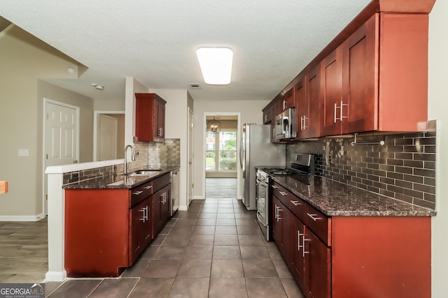 2801 Priestcliff Dr, Smyrna, GA 30080 - kitchen with appliances with stainless steel finishes, tasteful backsplash, reddish brown cabinets, a peninsula, and a textured ceiling