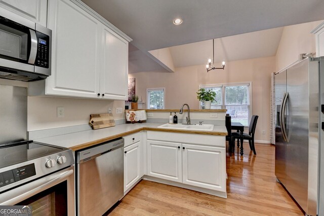 1635 Lake Heights Cir, Dacula, GA 30019 - kitchen with stainless steel appliances, a peninsula, light wood-style floors, white cabinetry, and recessed lighting