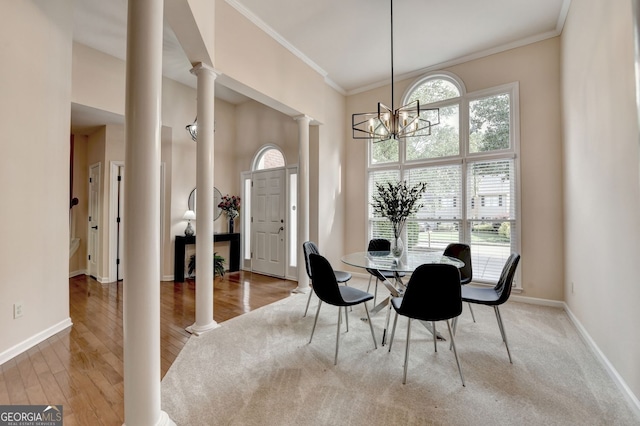 1635 Lake Heights Cir, Dacula, GA 30019 - dining space with ornate columns, ornamental molding, a chandelier, wood finished floors, and a high ceiling