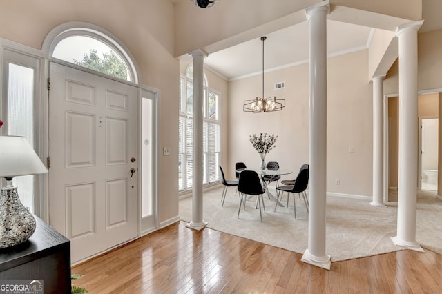 1635 Lake Heights Cir, Dacula, GA 30019 - entryway featuring ornate columns, light wood-style floors, crown molding, and a chandelier