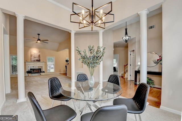 1635 Lake Heights Cir, Dacula, GA 30019 - dining area featuring ornate columns, ceiling fan, a fireplace, light carpet, and a high ceiling