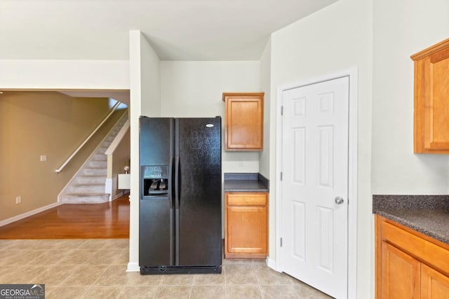 1936 Lakeshore Overlook Cir NW, Kennesaw, GA 30152 - kitchen with black fridge, dark countertops, brown cabinetry, and light wood finished floors