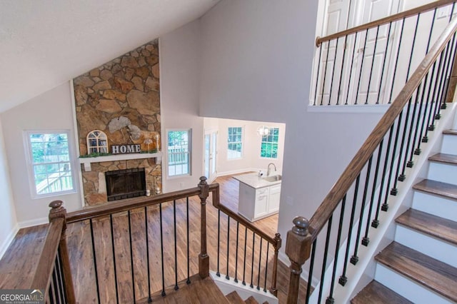 909 Shiloh Ridge Run NW, Kennesaw, GA 30144 - stairs featuring wood finished floors, high vaulted ceiling, and a fireplace